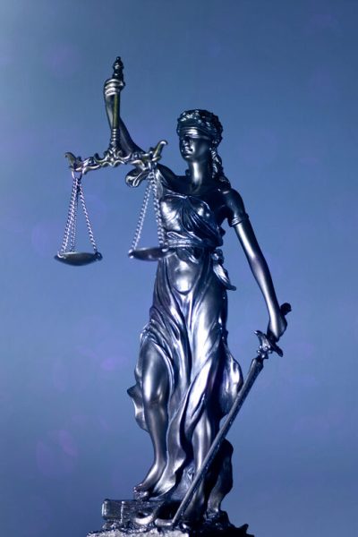 lady justice or justitia - blindfolded figurine holding balance scales - Panoamic image wih copy space.